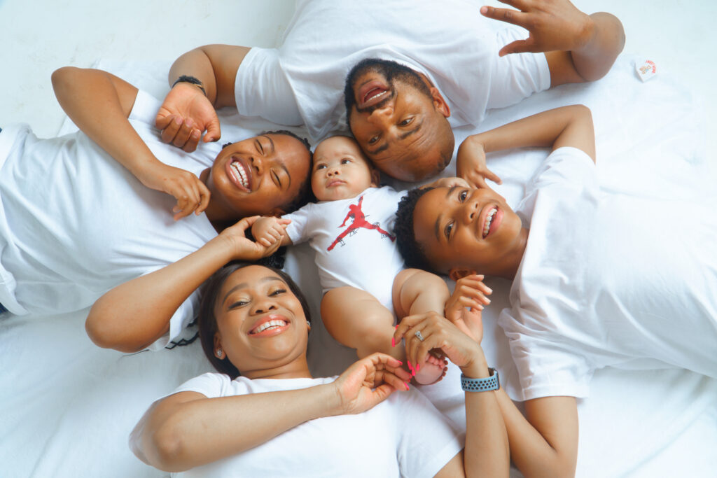 Family of five lying in a circle, smiling up at the camera