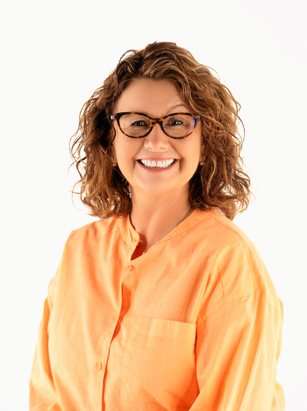 Smiling portrait in an orange shirt and glasses