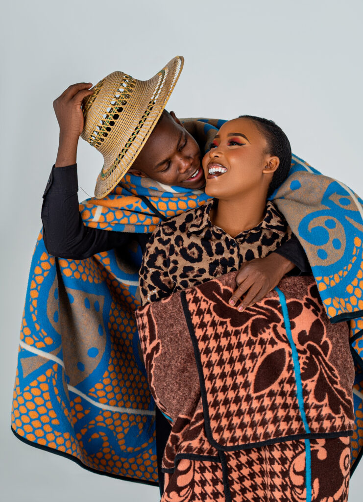 Couple wrapped in a patterned blanket, laughing together