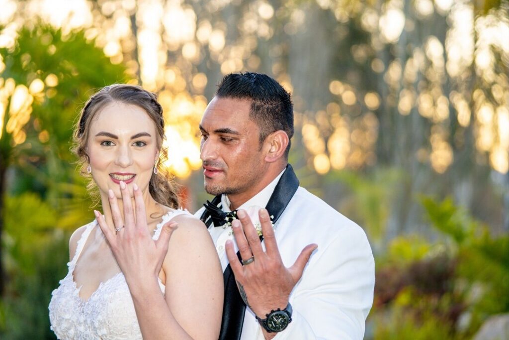 Frame from a wedding film: couple showing their rings