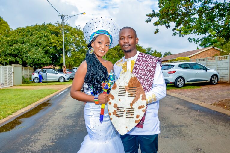 Couple holding a cowhide shield, the bride in a beaded headdress
