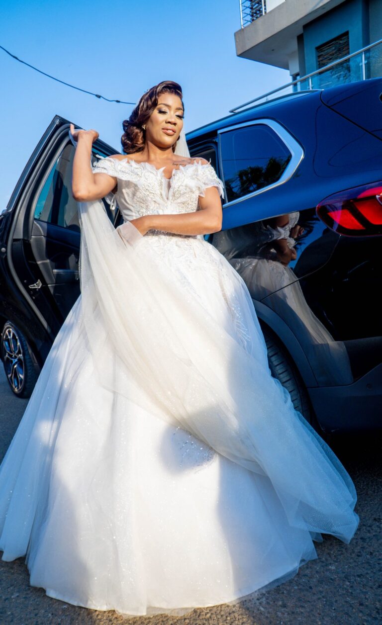 Bride stepping out of the car in a full white gown