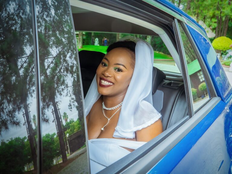 Bride smiling from the car window on her way to the ceremony