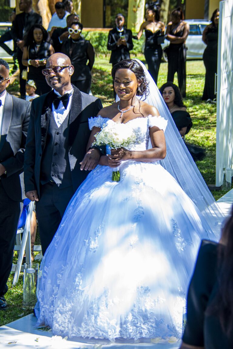 Bride walking down a garden aisle on her father's arm