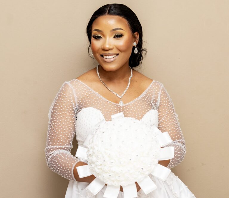Bride in a dotted-sleeve gown holding a white bouquet