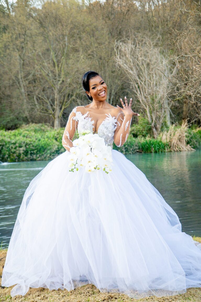 Bride showing her ring beside a lake