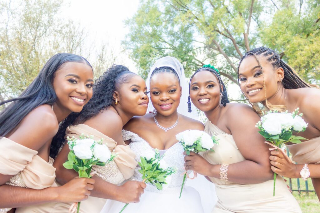 Bride surrounded by her bridesmaids holding white bouquets