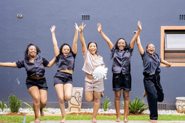 Bride and bridesmaids jumping for joy before getting dressed