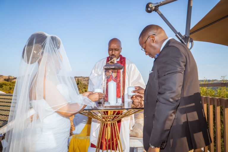 Bride and groom lighting a candle with the minister during the ceremony