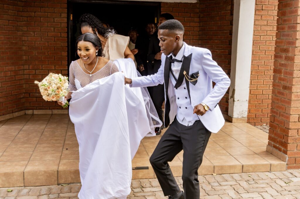 Couple dancing out of the doorway after their ceremony