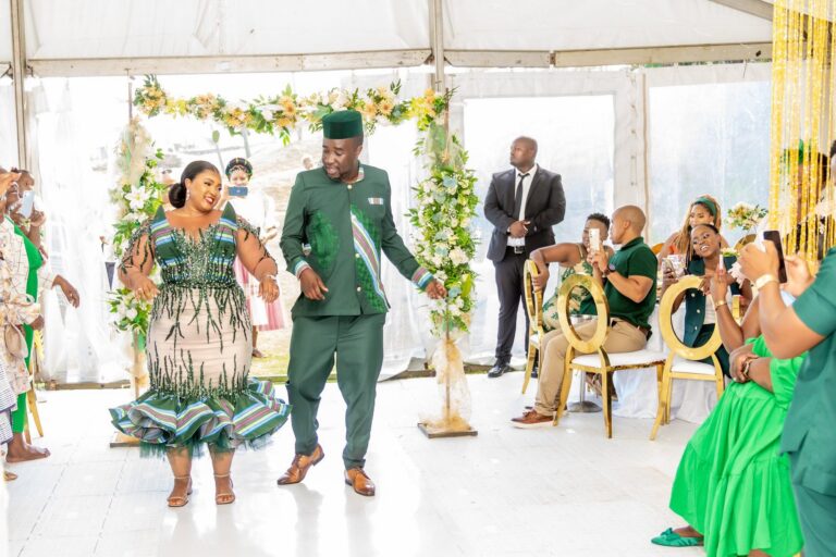 Couple dancing into their reception as guests look on