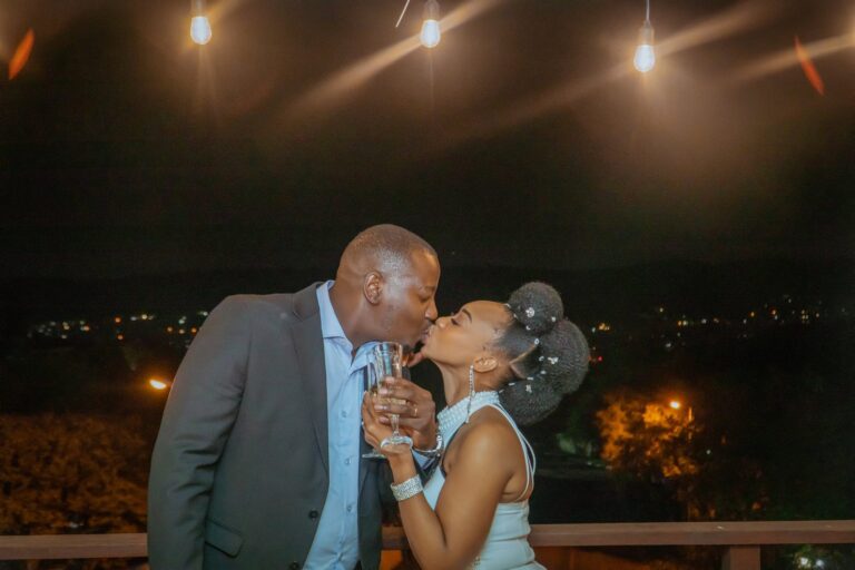 Couple kissing under string lights at night