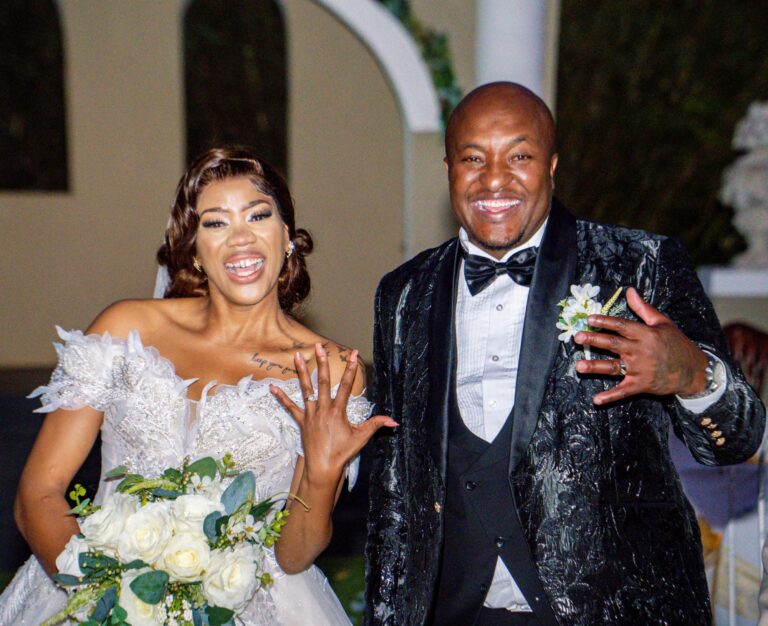 Newlyweds laughing and showing their wedding rings