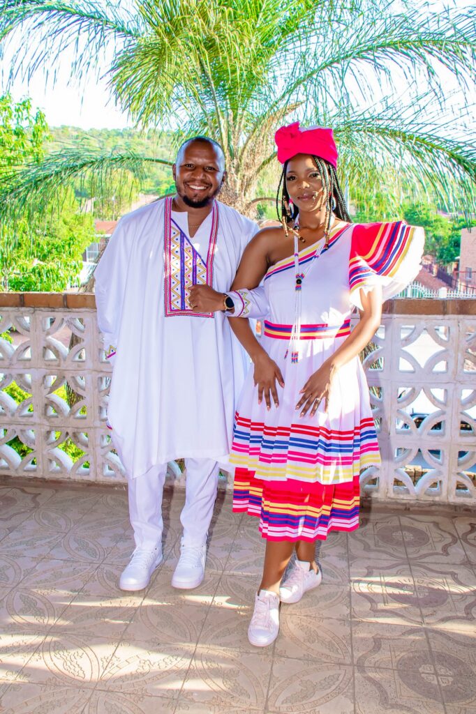 Couple in traditional dress standing together on a veranda