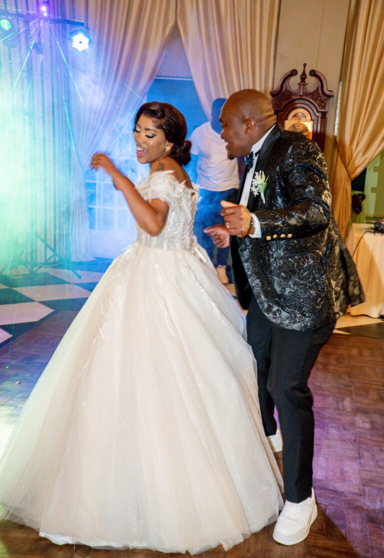 Couple dancing together at their reception under stage lights