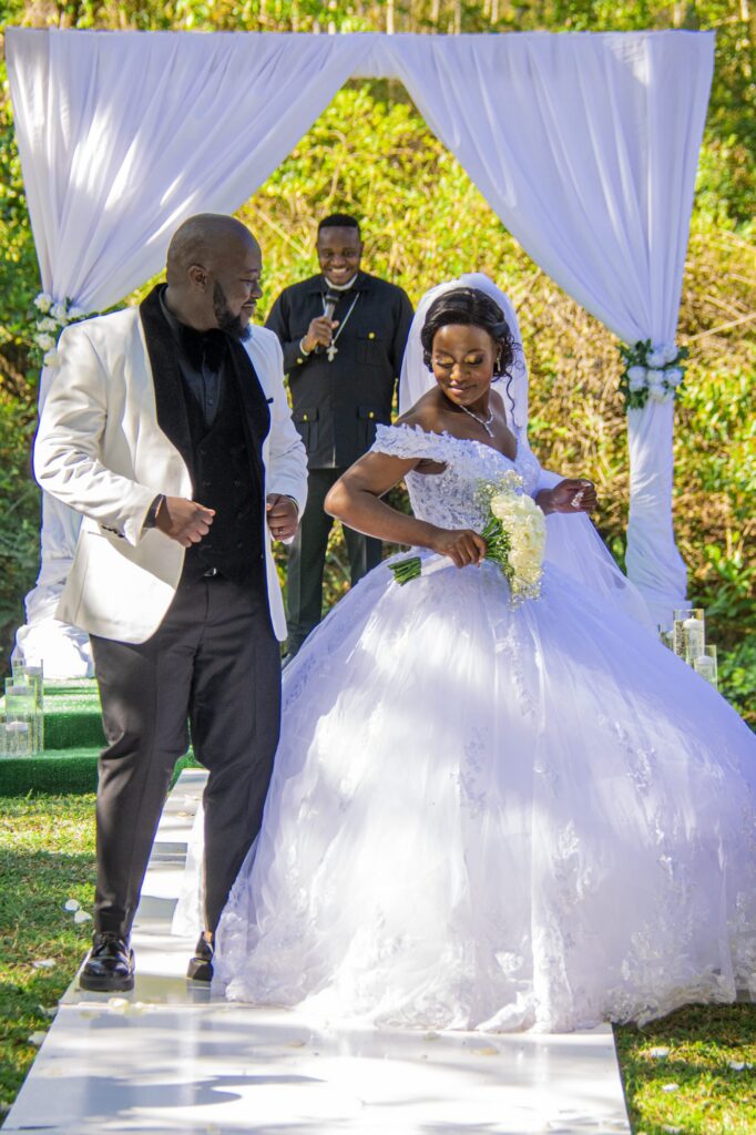 Groom dancing towards his bride at the altar as the pastor looks on