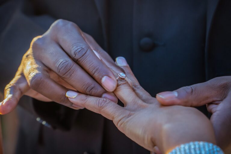 Groom placing the ring on his bride's finger