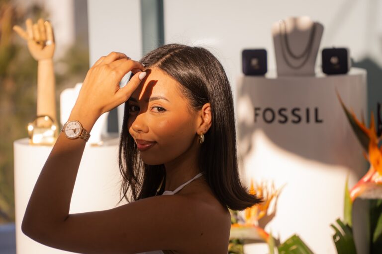 Guest posing beside the watch and jewellery display at the Fossil brand activation