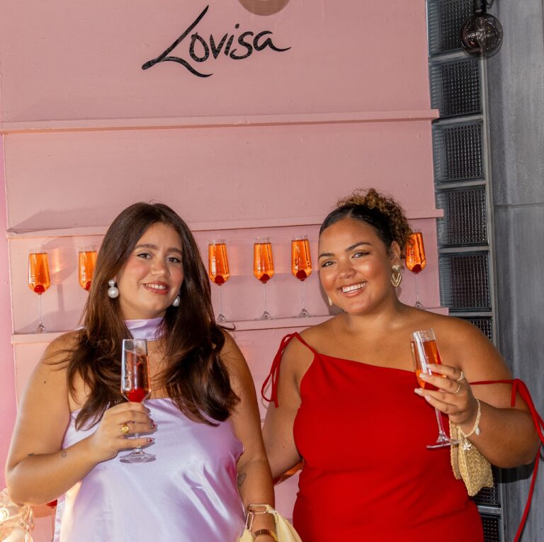 Guests raising drinks in front of the branded wall at the Lovisa brand activation