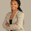 Professional headshot, checked blazer, arms crossed, warm smile, by Studio24.7