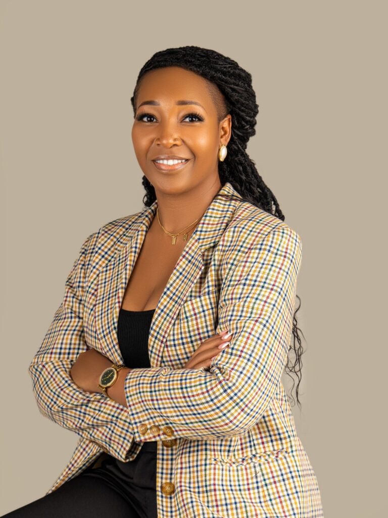Professional headshot, checked blazer, arms crossed, warm smile, by Studio24.7