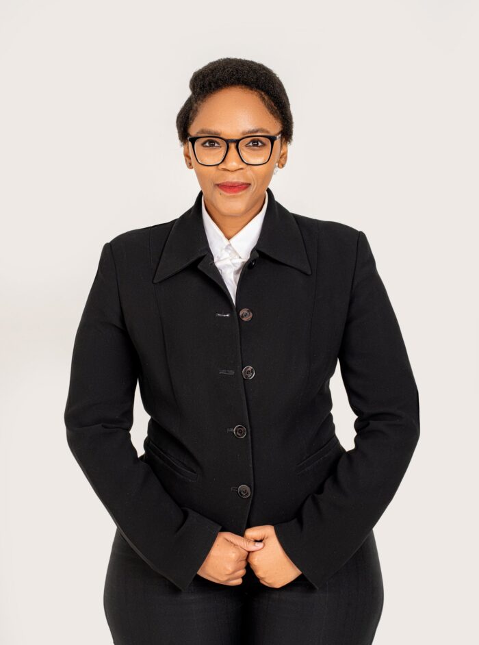 Professional headshot, black jacket and glasses on a white backdrop, by Studio24.7