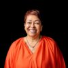 Professional headshot, orange blouse, big smile on a black backdrop, by Studio24.7
