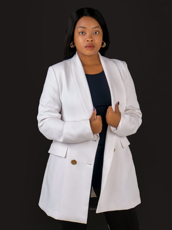 Professional headshot, white blazer on a black backdrop, by Studio24.7
