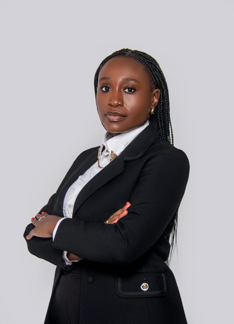 Professional headshot, black blazer, arms crossed, on a light grey backdrop, by Studio24.7