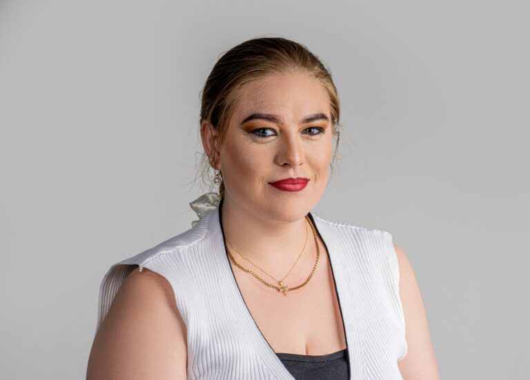 Professional headshot, white sleeveless top on a grey backdrop, by Studio24.7