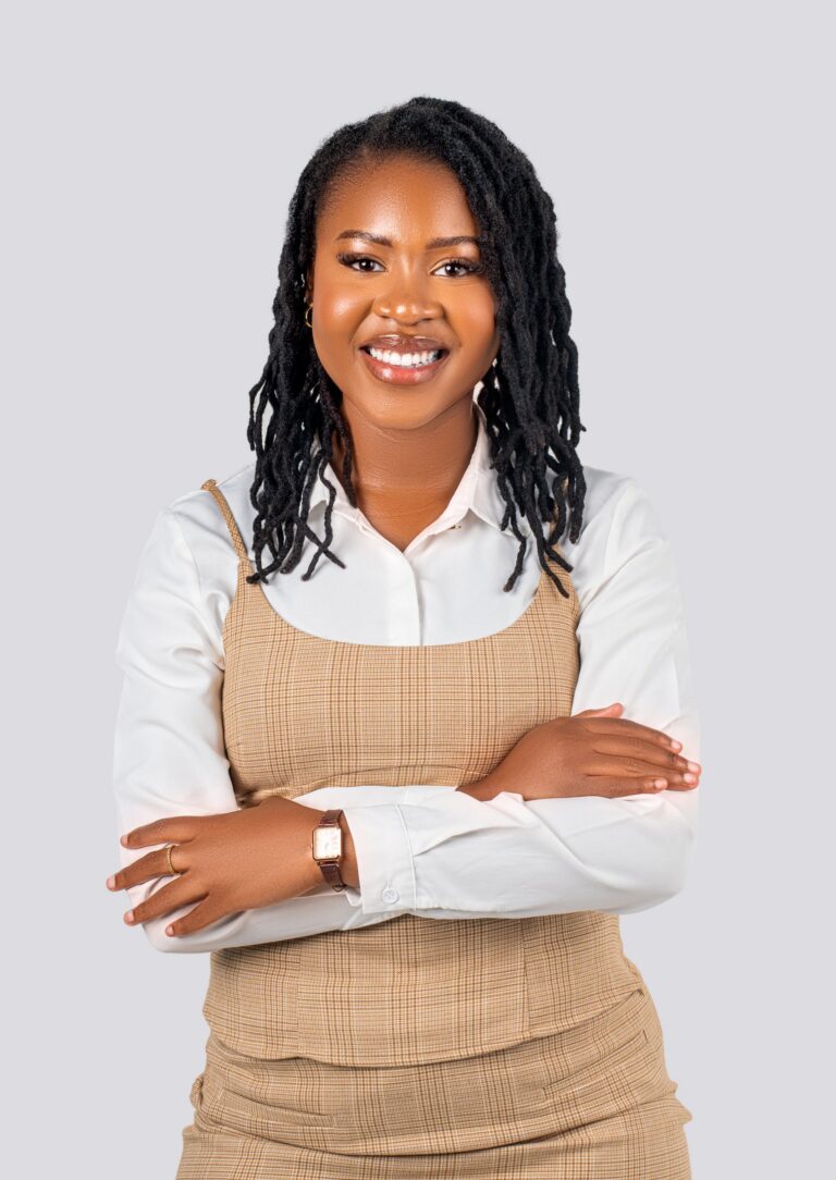Professional headshot, white shirt and check pinafore, arms crossed, by Studio24.7